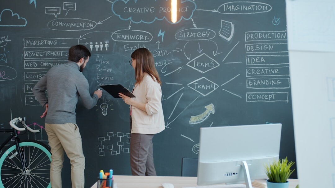Startup team brainstorming around whiteboard in modern office